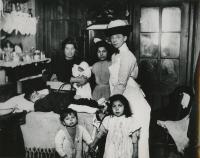 Nurse at bedside with young male patient on bed and family of five around him.